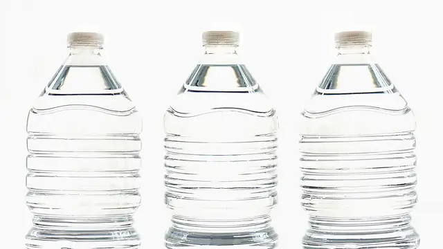 Três garrafas plásticas transparentes cheias de água, dispostas lado a lado