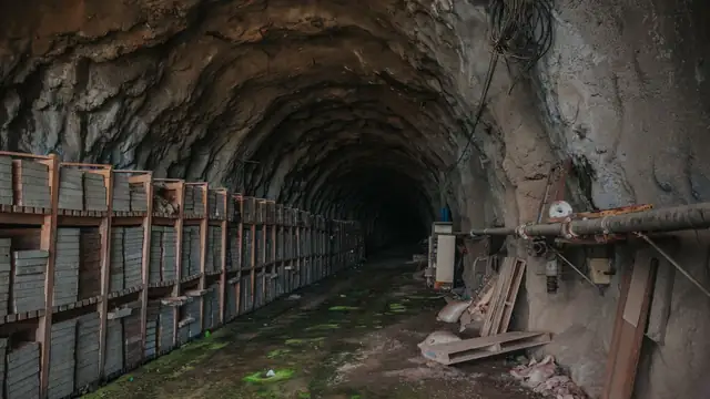 Túnel subterrâneo com equipamentos e material industrial armazenado