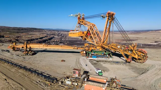 Vista aérea de escavadeira de grande porte operando em cava de mineração a céu aberto