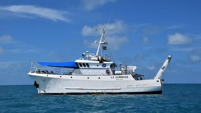 Navio de pesquisa navegando em mar calmo sob céu limpo