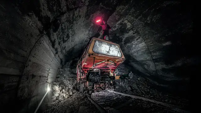 Túnel escuro com veículo abandonado e uma luz acesa ao fundo