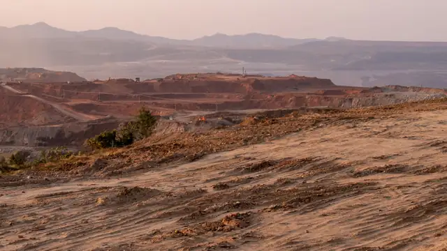 Vista aérea de paisagem desértica com atividade de mineração e montanhas ao fundo