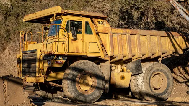 Caminhão fora de estrada de grande porte em área de operação industrial durante o dia