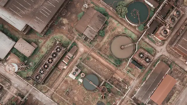 Vista aérea de fábrica antiga com tanques circulares de decantação em estação de tratamento de água
