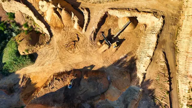 Vista aérea de uma grande mina a céu aberto em dia de sol