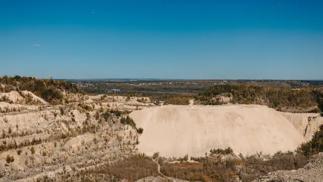 Vista ampla de uma área de mineração a céu aberto sob céu azul limpo