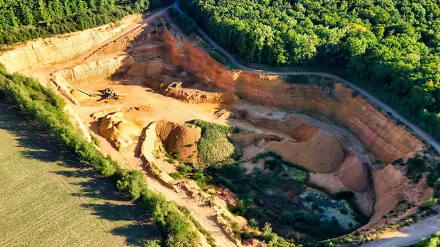 Vista aérea de cava de mineração cercada por vegetação
