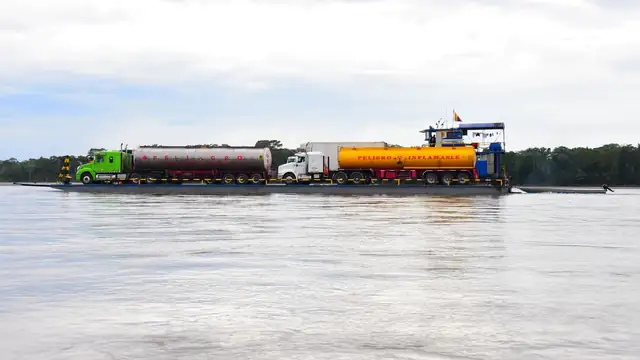 Barcaça com caminhões-tanque navegando em rio de grande porte na Amazônia