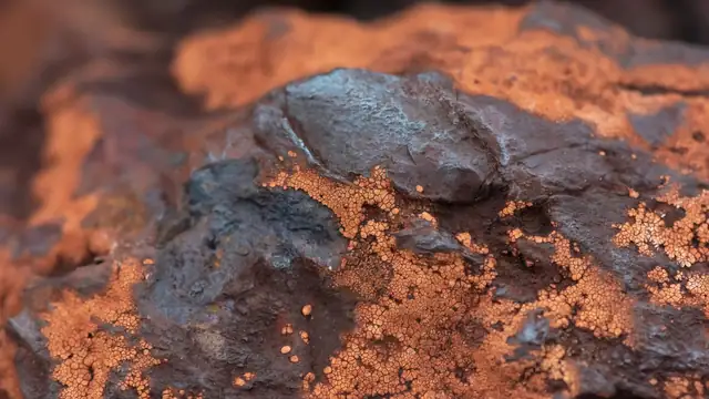 Textura detalhada de minério de ferro, com tons terrosos e estrutura mineral