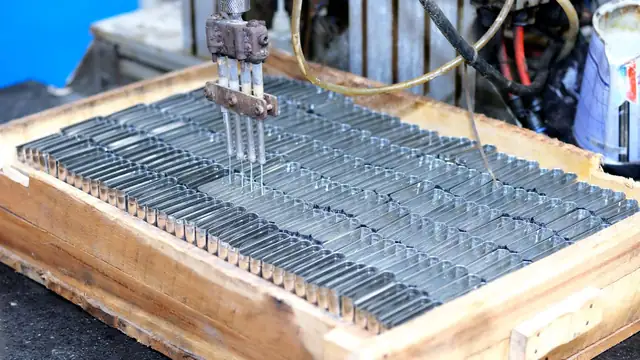 Close-up de máquina automatizada processando peças metálicas em ambiente industrial