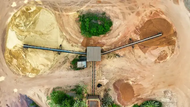 Vista aérea de área de mineração com esteiras transportadoras e pilhas de material