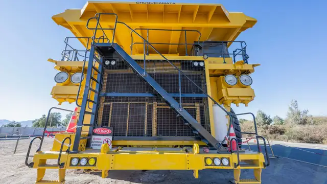 Grande caminhão amarelo de mineração em uma mina a céu aberto, em dia de sol