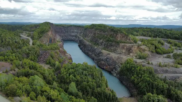Vista aérea de uma mina de ferro cercada por vegetação verde